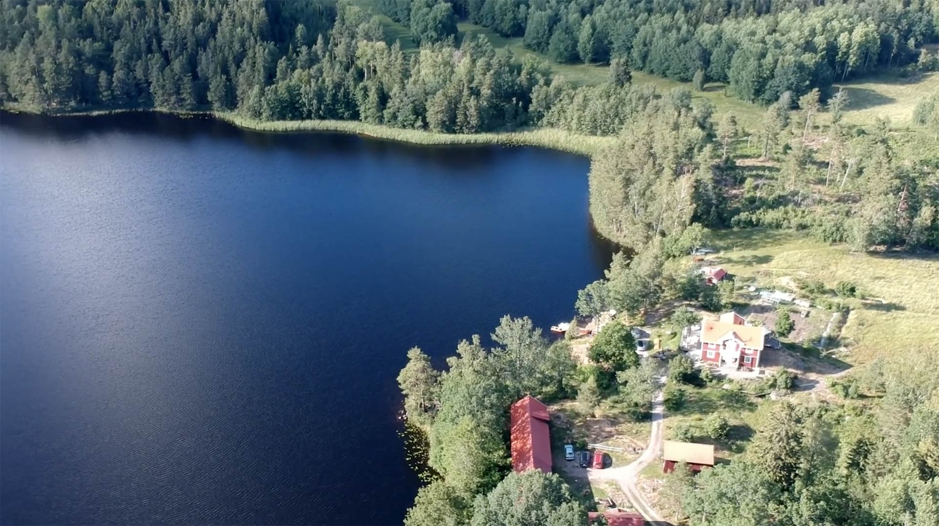 Aerial view of the Veskijärve property with red house by the lake